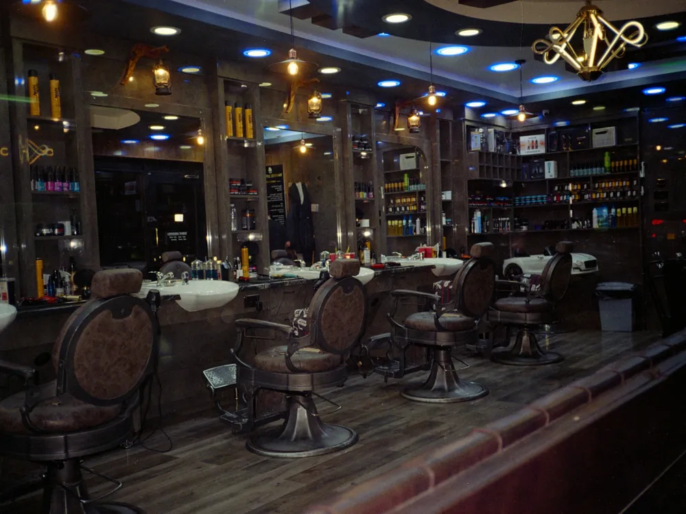 A dark barbershop with a row of chairs