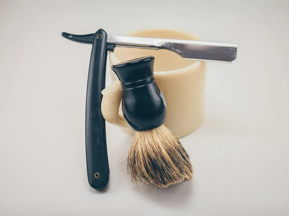 A straight razor and a shaving brush
