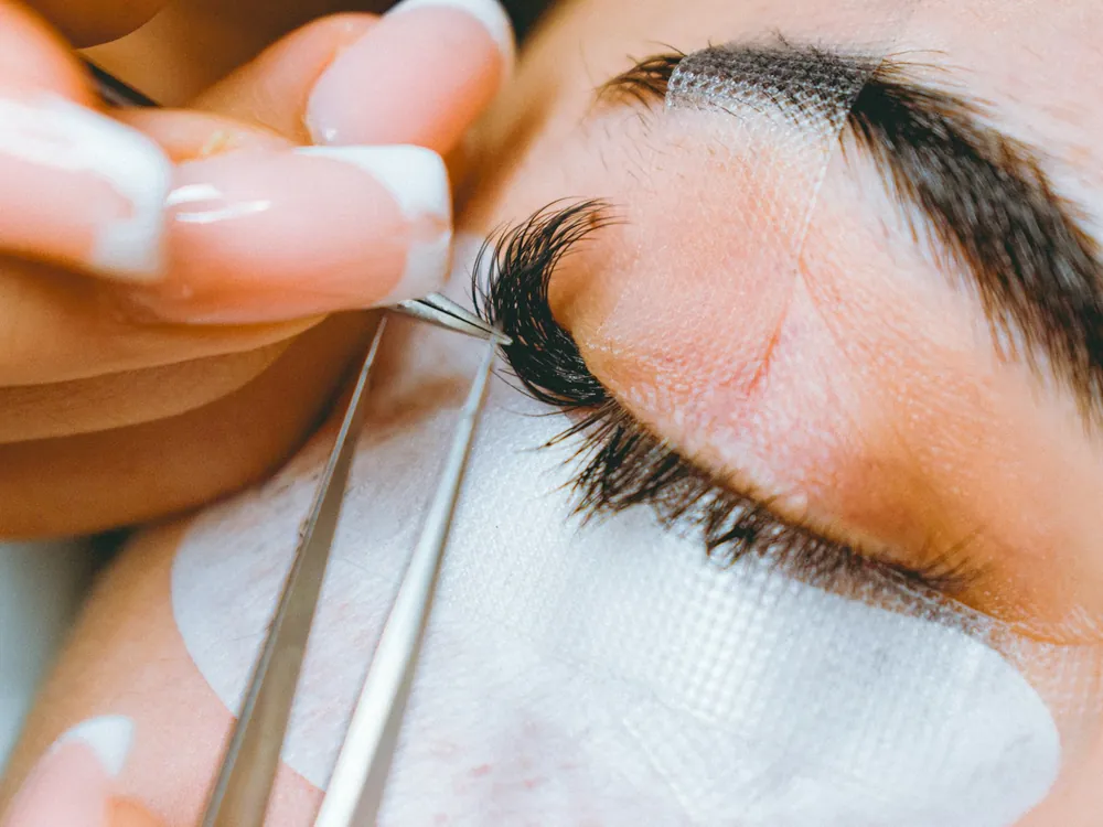 A close-up of lash extensions being applied
