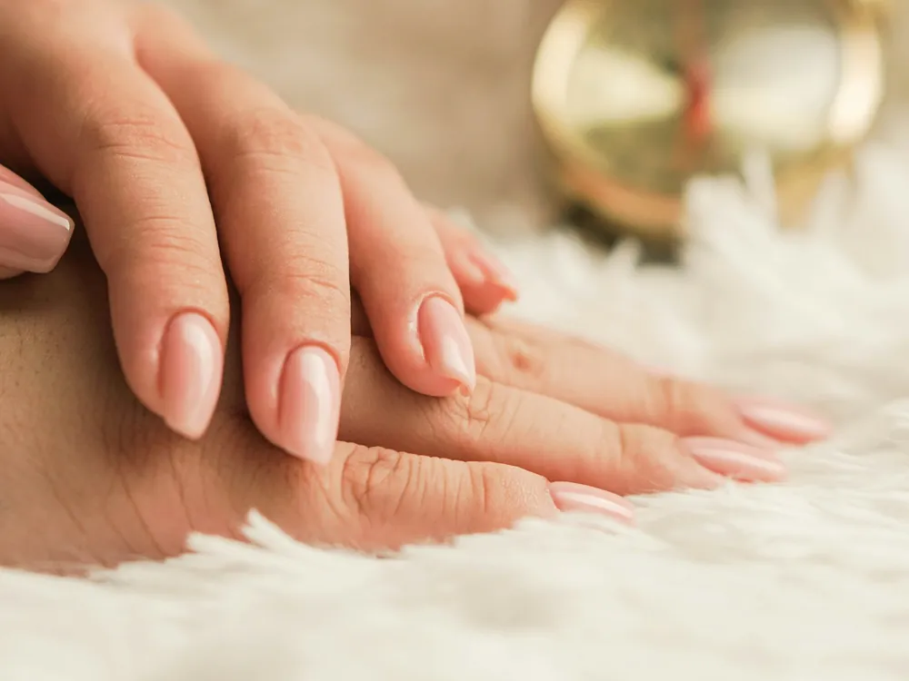 Manicured hands on a soft cloth
