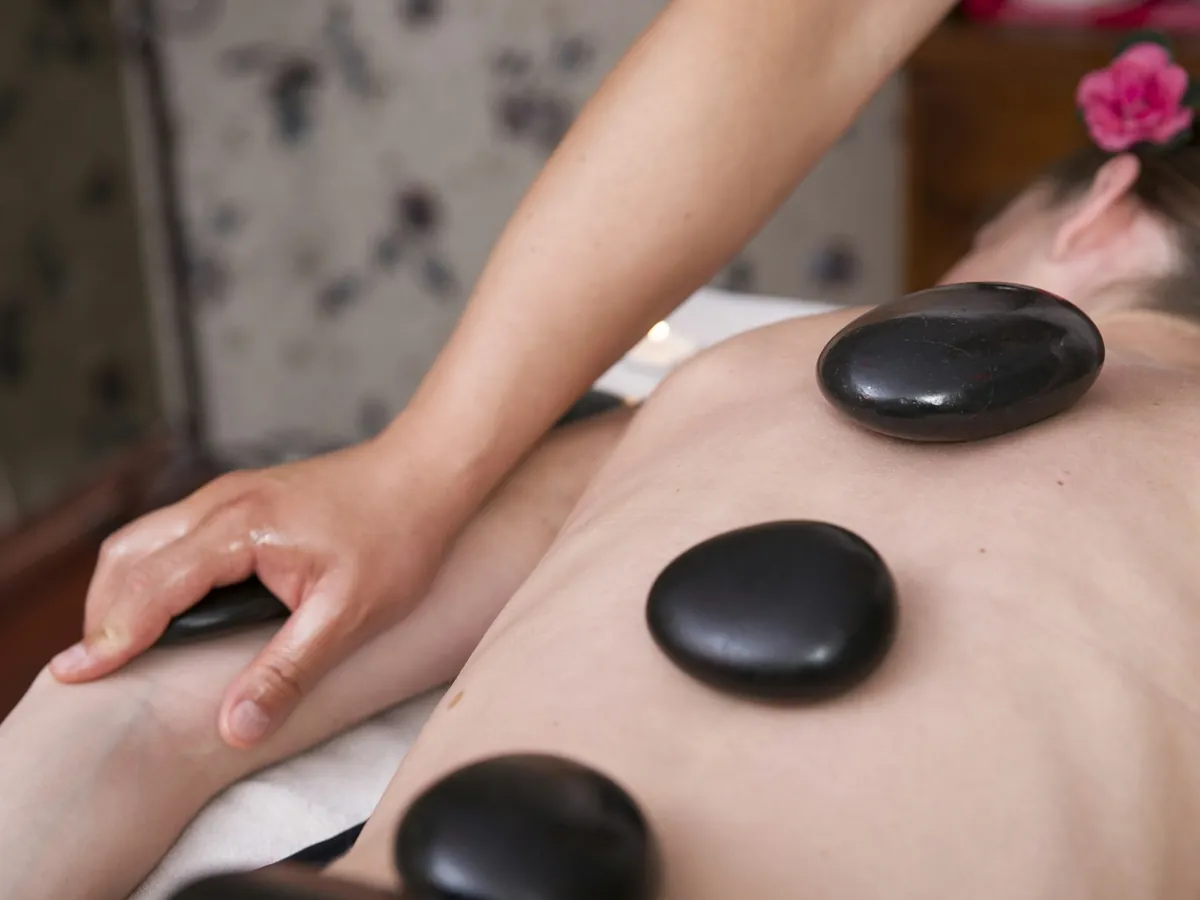 Hot stones placed along a back