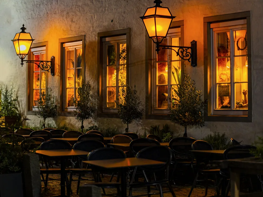 Outdoor restaurant tables lit at night
