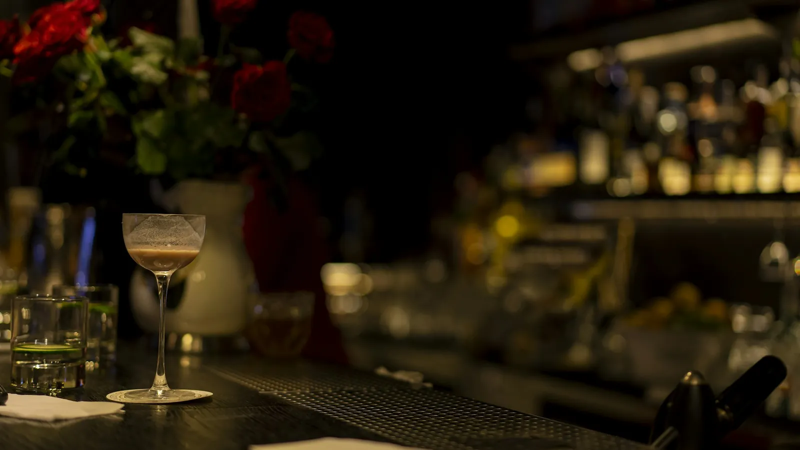 A dim lounge bar with glasses on the counter