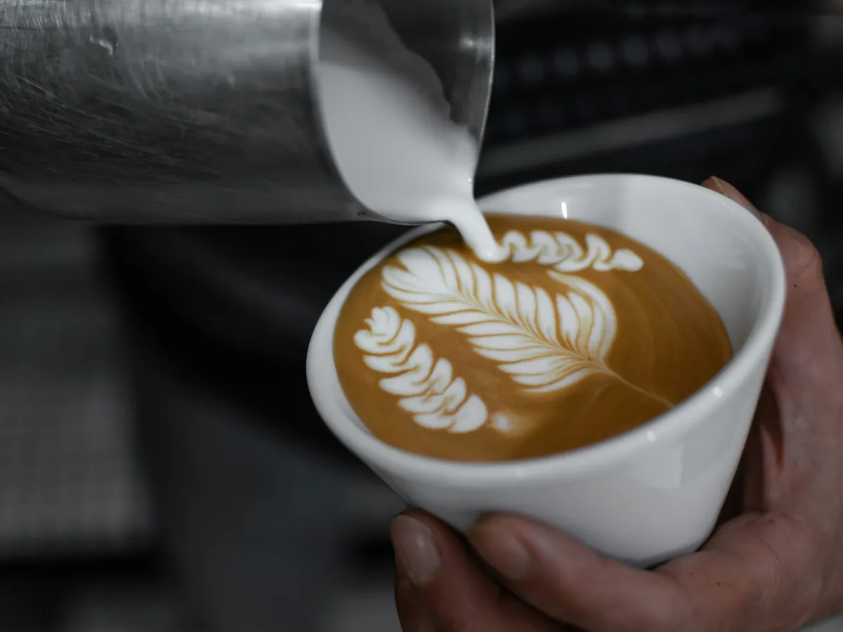 Latte art being poured into a cup
