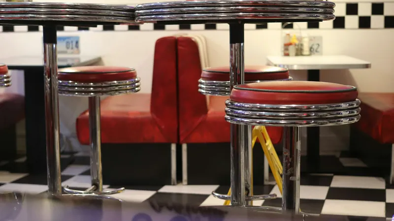 Diner booths and stools on a checkered floor