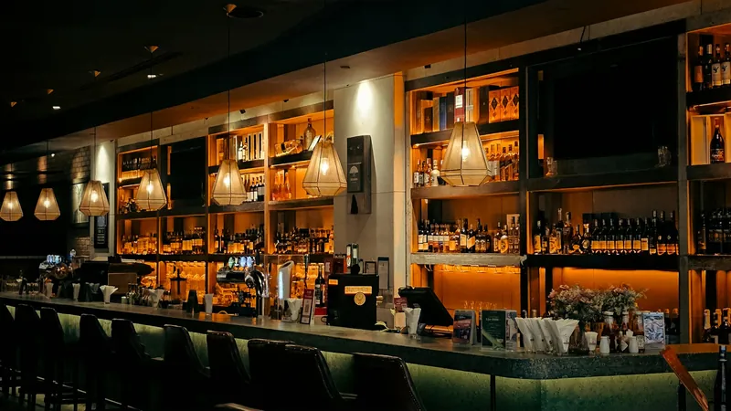 A dim bar with shelves of bottles