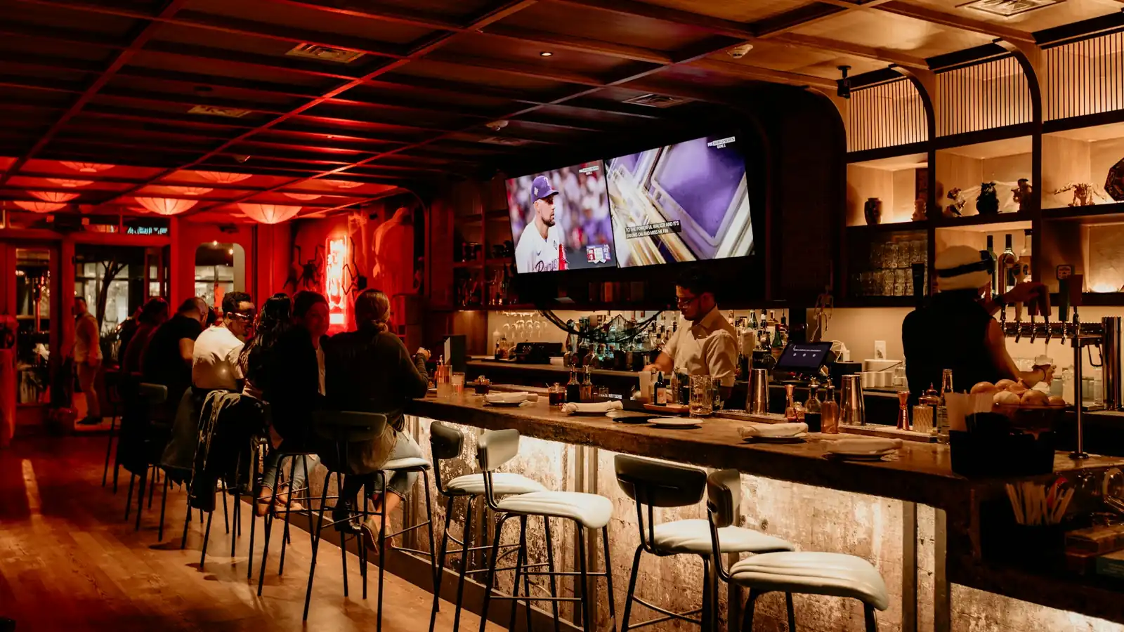 A bar room with televisions above the counter
