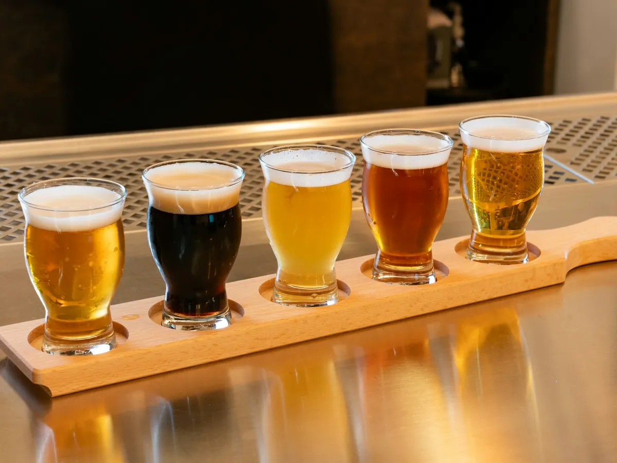 A flight of beers on a wooden paddle