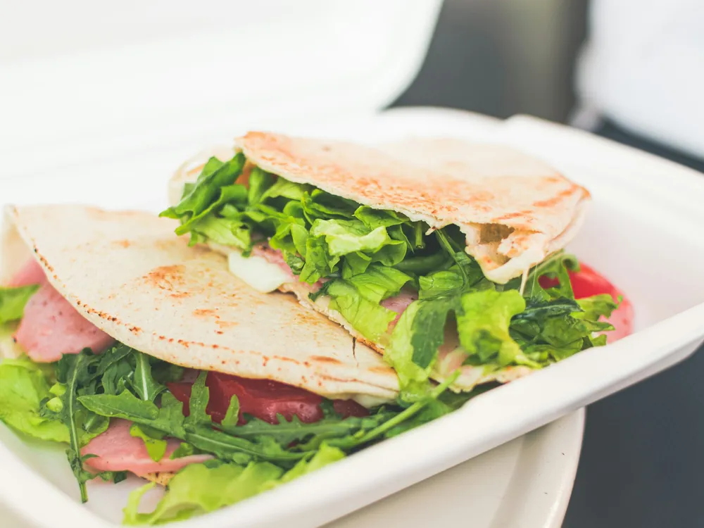A wrap with salad in a container