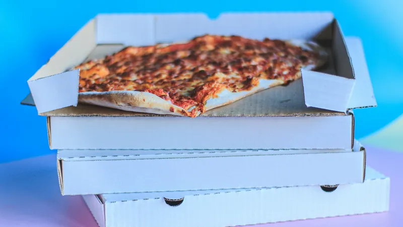 Pizza boxes stacked with a pizza on top