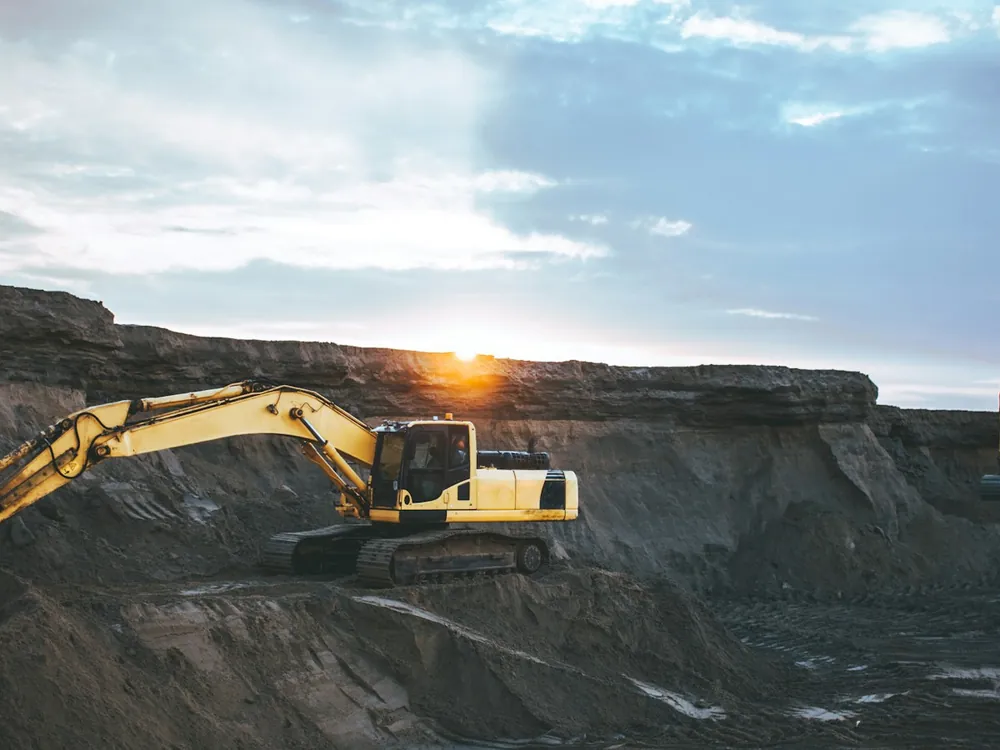 An excavator on a site at sunrise