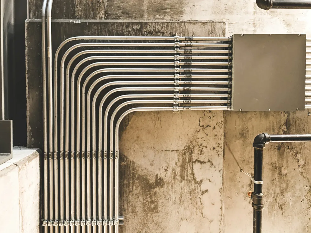 Metal pipes along a concrete wall
