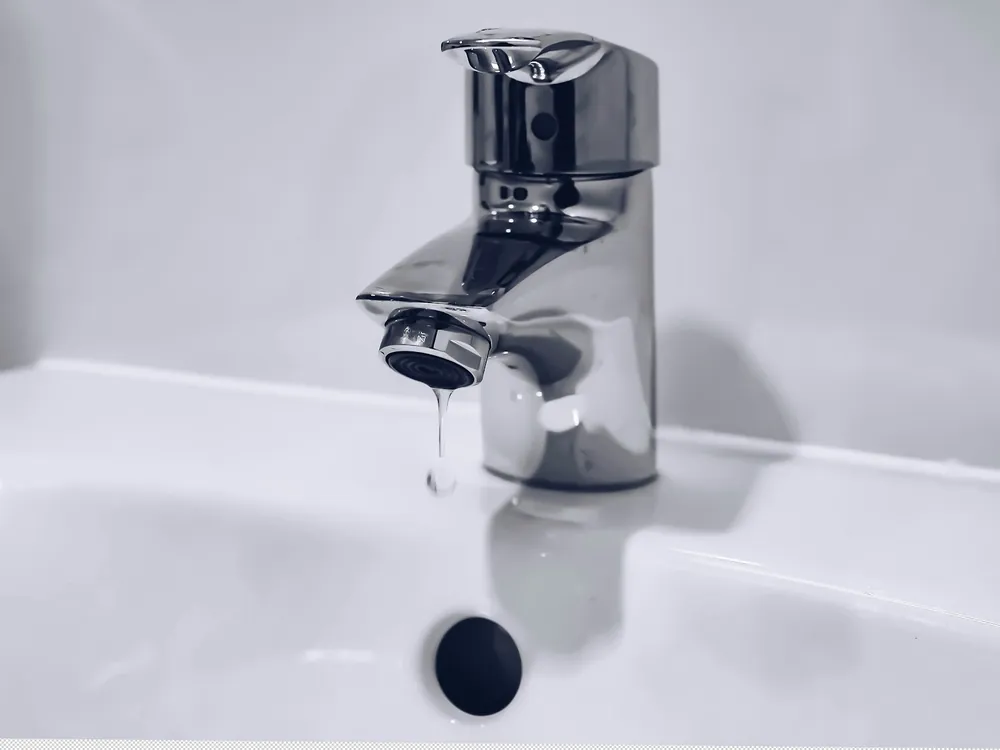 A chrome faucet over a basin