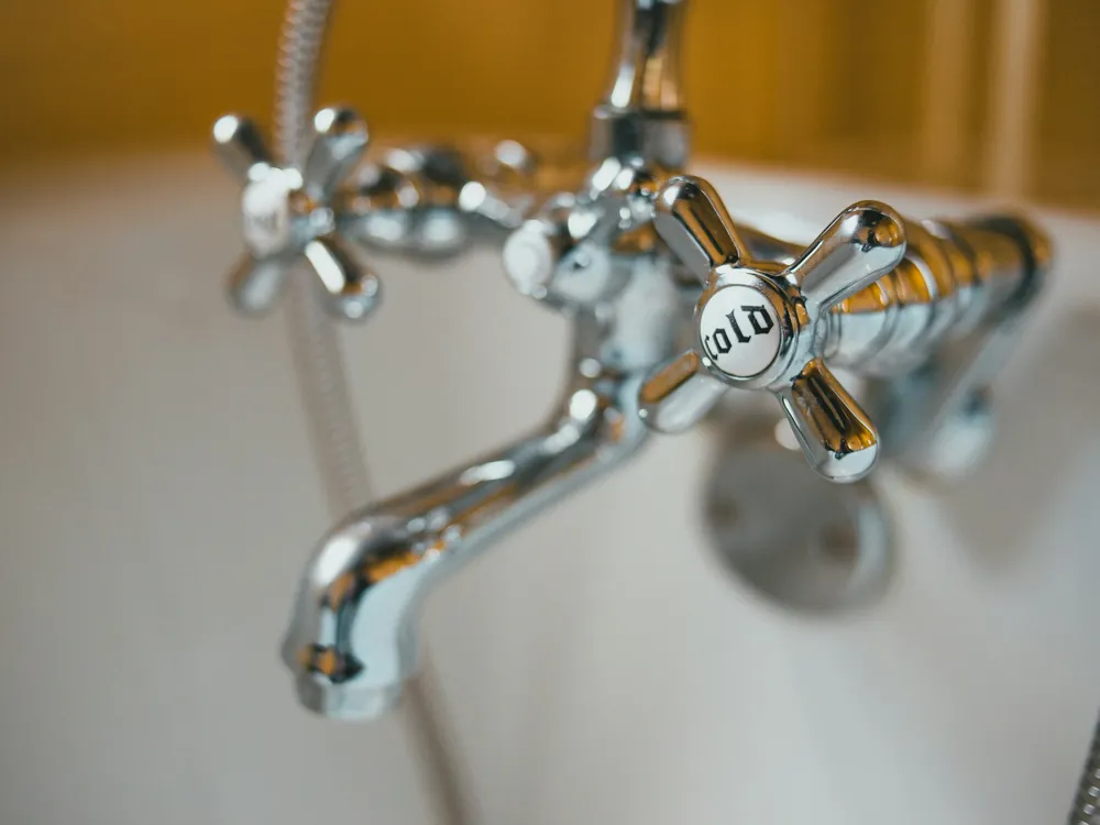 A chrome tap with water droplets